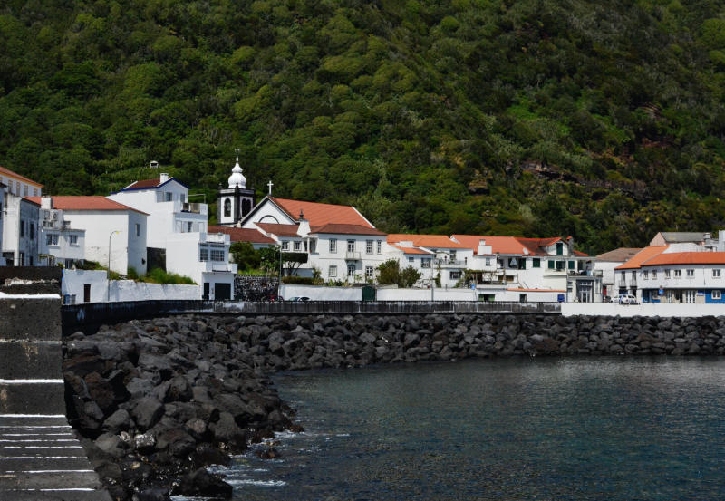 Whitewashed houses and buildings behind a stone wall surrounding a harbour