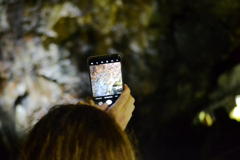 A tourist takes photos within a cave 