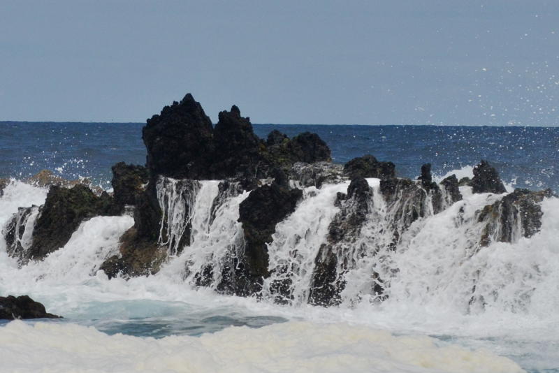 Sea spray over lava rocks by the ocean