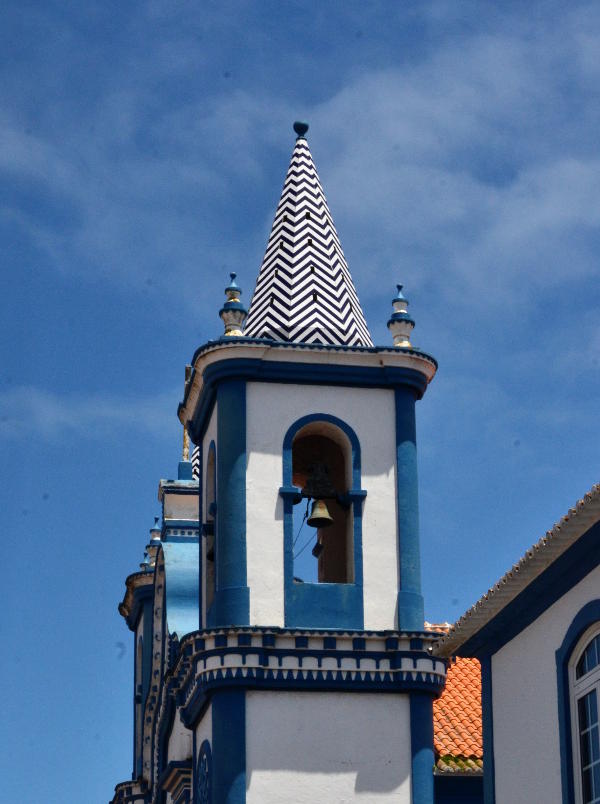 A church tower with pointed roof and blue edging