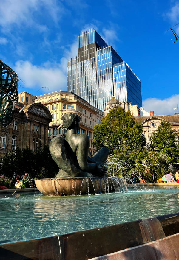 The Floozie in the Jacuzzi with old and modern buildings behind it