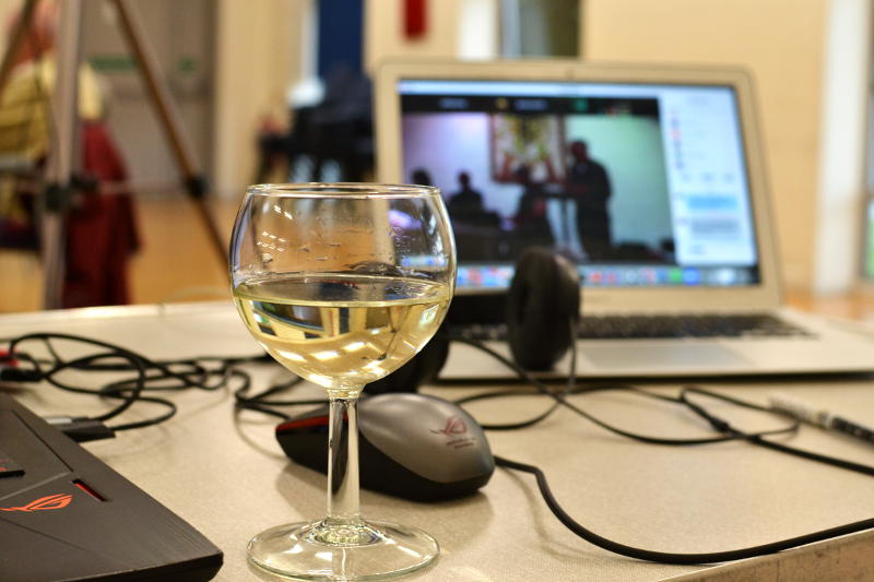 A glass of wine in front of a computer screen