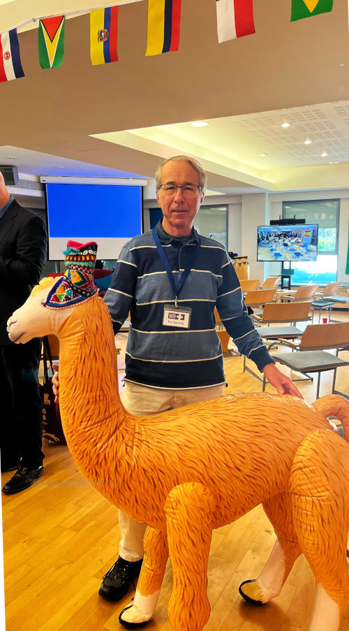 Phil standing behind an inflatable alpaca in a conference room