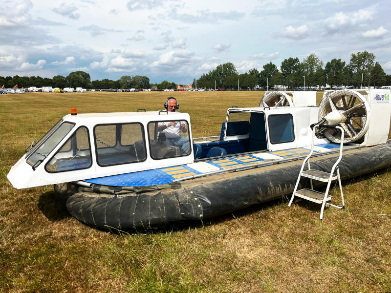 A small hovercaft on the ground in a grassy field