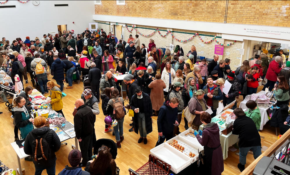 View of a crowded market in the main hall at Stirchley Baths