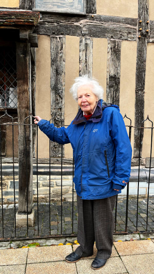 Hanna stands in front of a half-timbered building