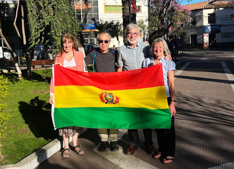 Alison, Phil, John and Elsie holding a Bolivian flag in a city square