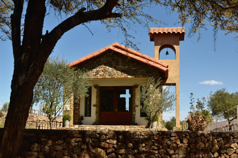 A small chapel with a cross cut out of the back wall, and small bell tower at the side