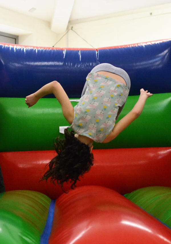A figure on a bouncy castle, upside down in mid air
