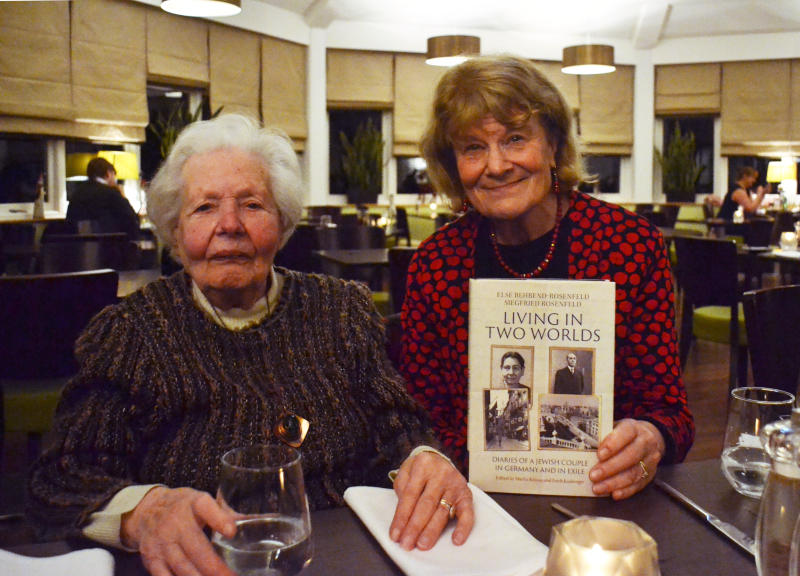 Hanna with Deborah Langton, who is holding a copy of the book "Living in Two Worlds", in a restaurant