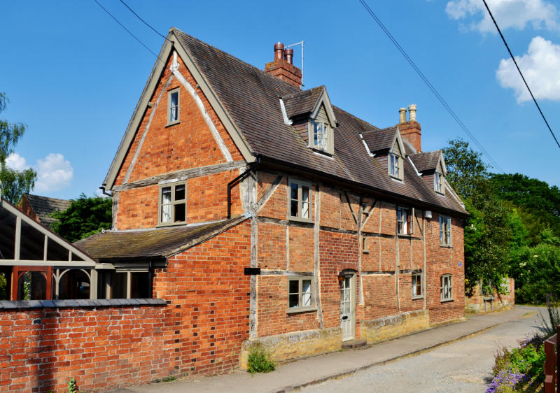A large timber-framed house in bright sunshine