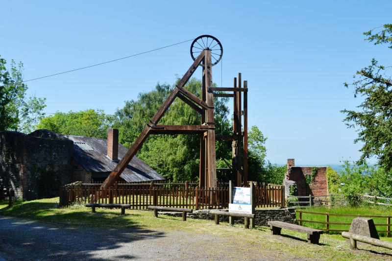 A mine winding wheel mounted on top of a tall triangular wooden frame