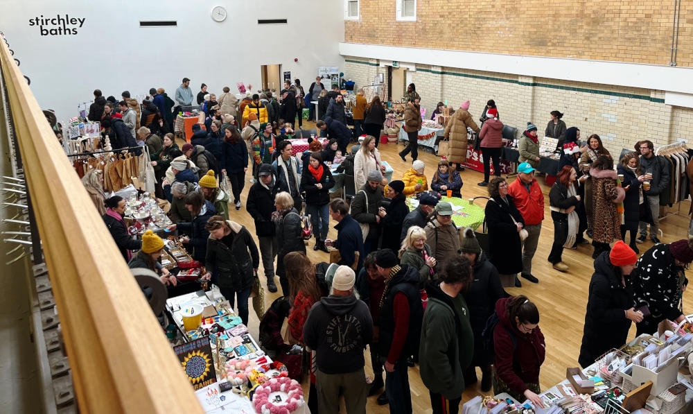 View of a crowded market in the main hall at Stirchley Baths
