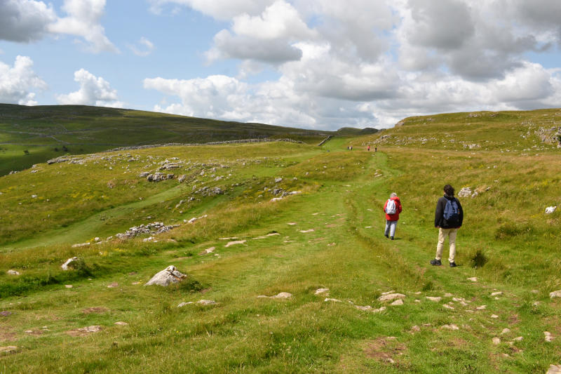 Miriam and Martin walking away from the camera across open moorland