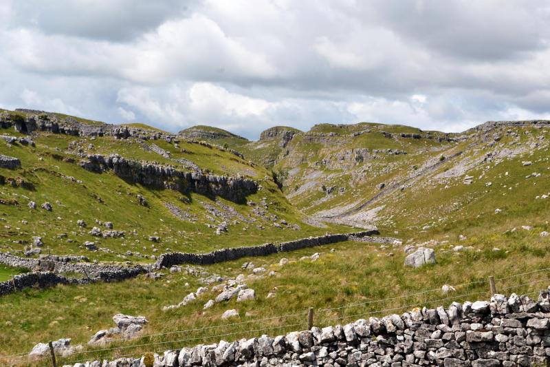 View over a stone wall towards rocky hills