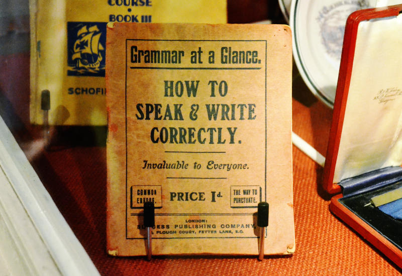 An old booklet: "How to Speak & Write Correctly", price 1 shilling, in a glass case
