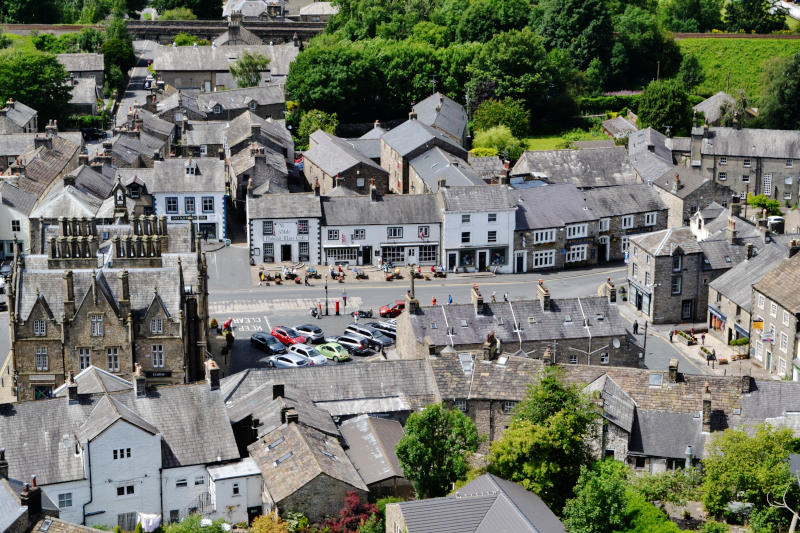 View looking down over grey roofs and mainly white buildings in the middle of Settle
