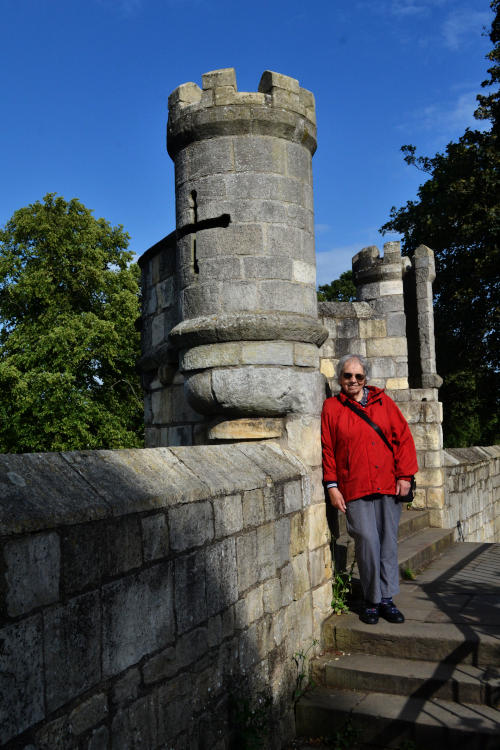 Miriam standing next to a medieval tower on the city wall