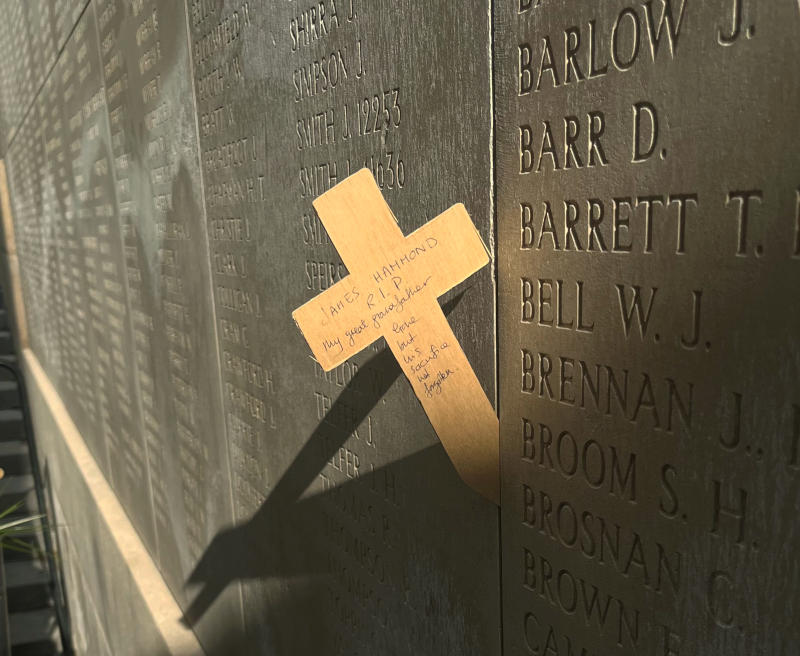 Thin wooden cross inserted into a gap between panels in the Menin Gate: "James Hammond RIP My great-grandfather. Gone but his sacrifice not forgotten"