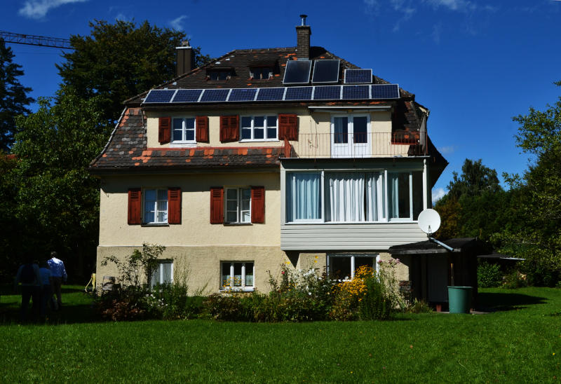 A large 3-storey house set in a grassy garden