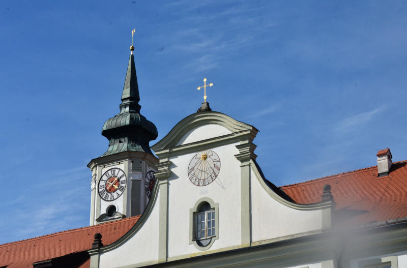 A clock on a spire, and a sundial on a neighbouring frontage