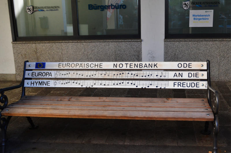 Bench outside a bank, on which is written - in staff notation - the tune of Ode to Joy
