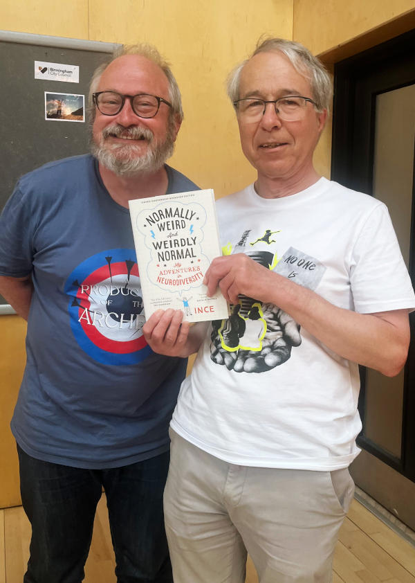 Robin Ince standing next to Phil who is holding up a copy of Robin's book "Normally Weird and Weirdly Normal"