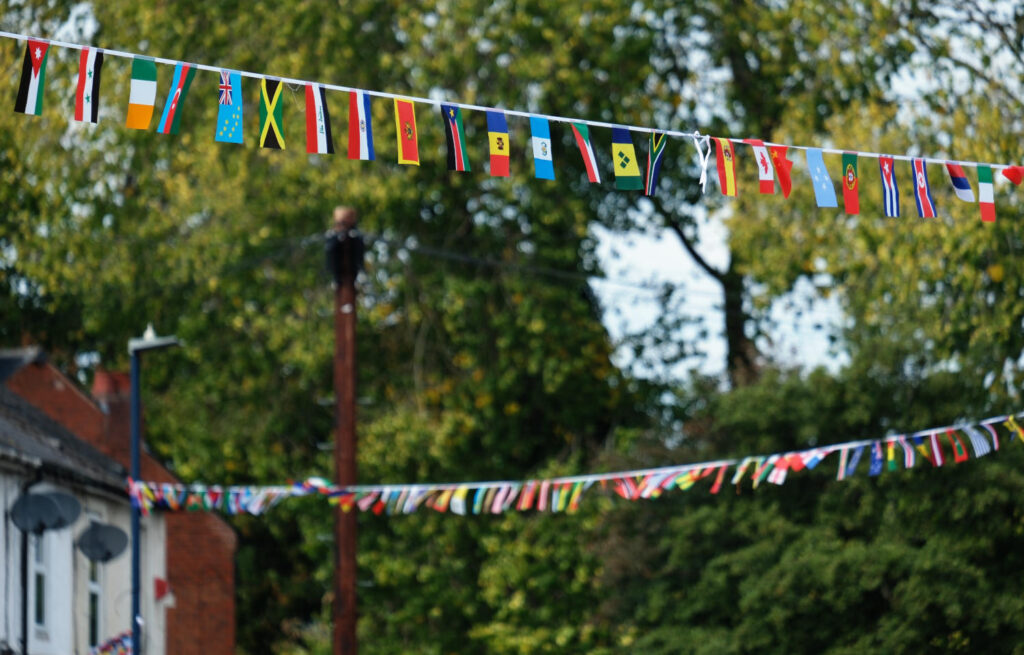 Rows of small multinational flags strung up from lines across a street
