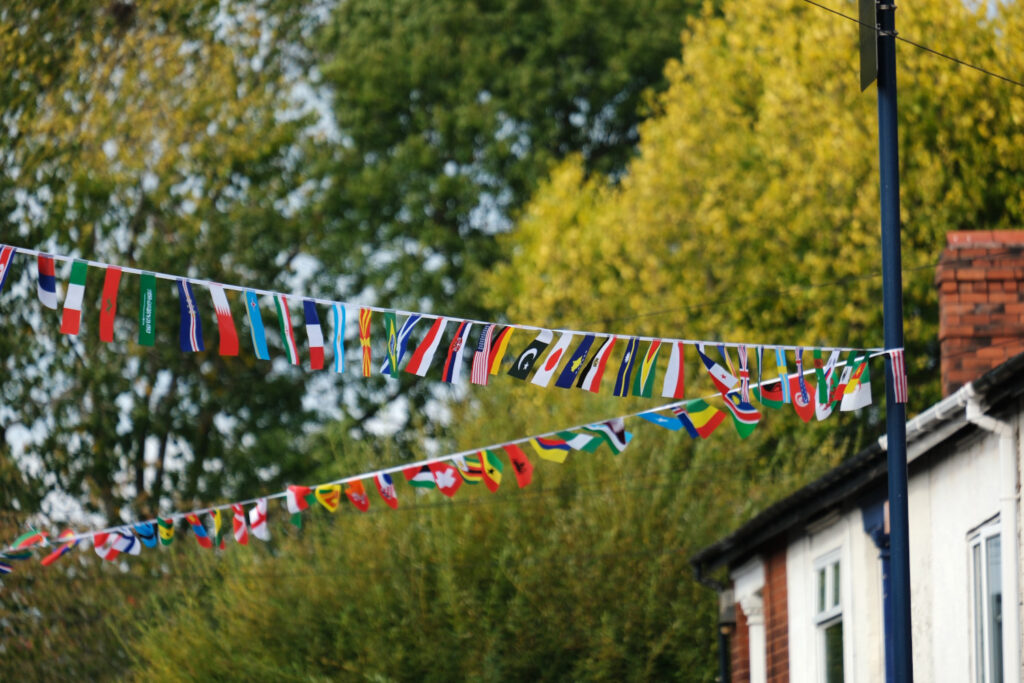 Rows of small multinational flags strung up across a street